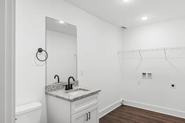 a bathroom with a granite countertop sink toilet and vanity