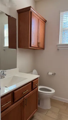 a bathroom with a toilet a sink and mirror
