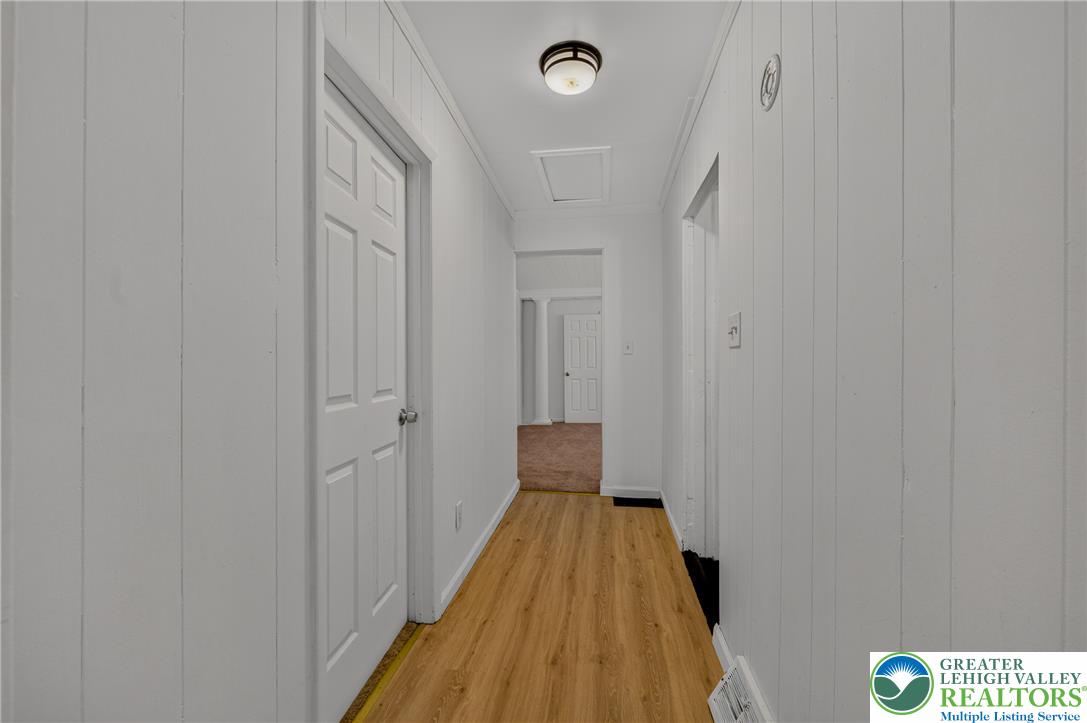 313 Main Street Slatington, PA 18080 - Photo 10 of 73 A well-lit hallway with natural wood flooring offers a clear pathway to other areas of the home.