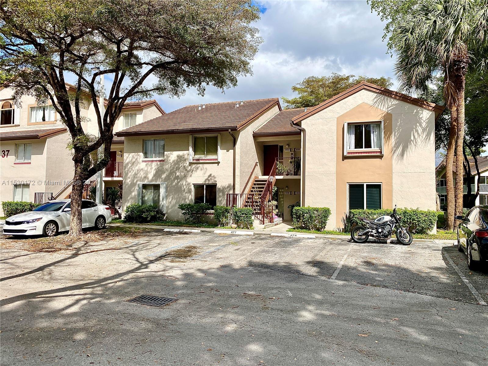 9201 Southwest 138th Place, Unit 9201 Miami, FL 33186 - Photo 1 of 20 a view of a white house with a large tree s