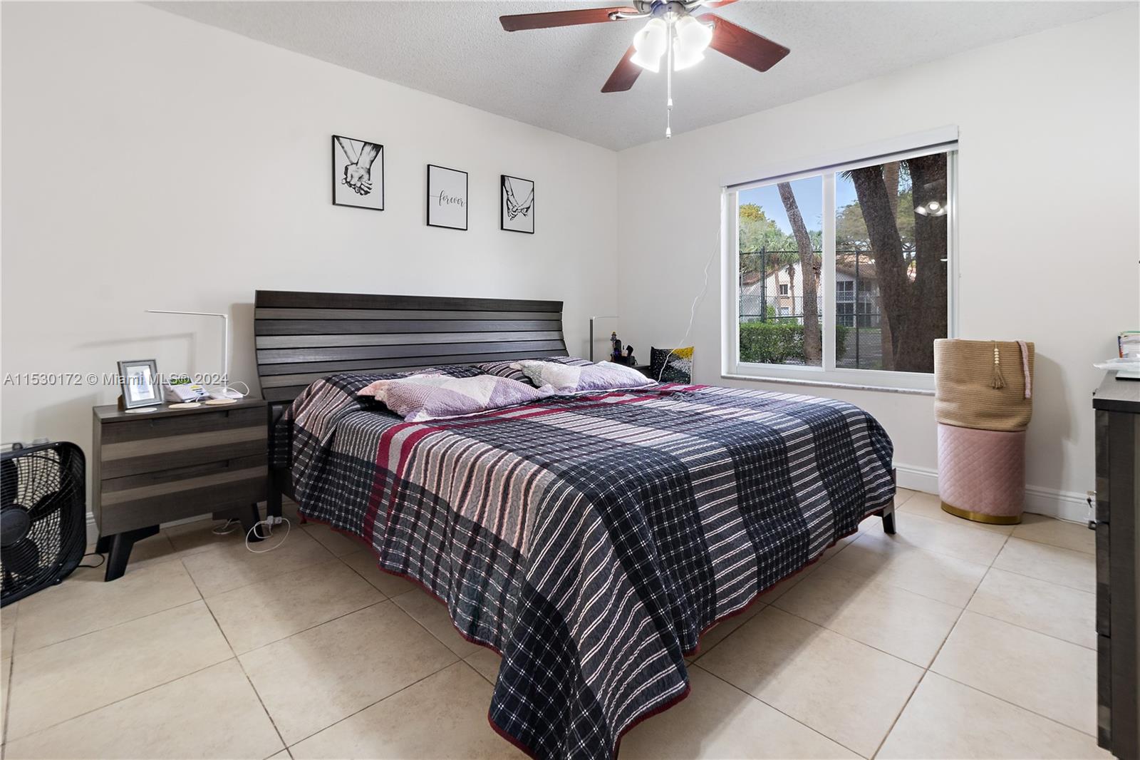 9201 Southwest 138th Place, Unit 9201 Miami, FL 33186 - Photo 12 of 20 a bedroom with a bed and a chandelier