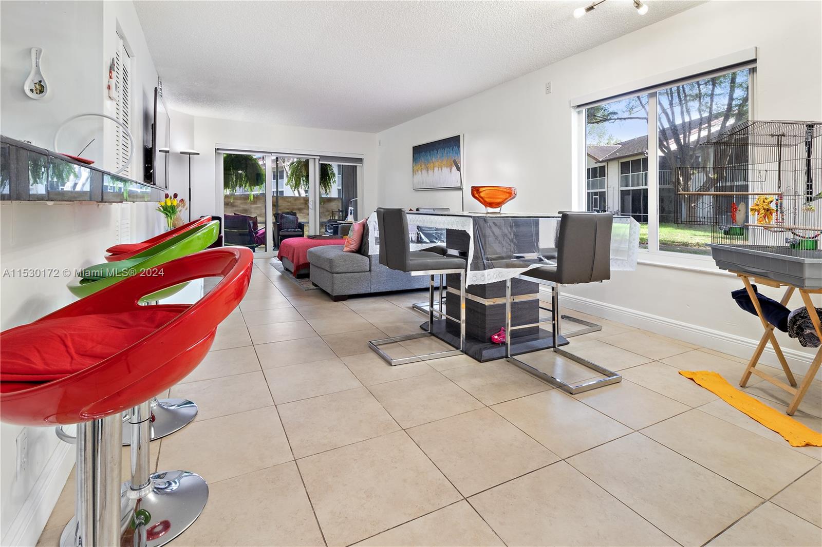 9201 Southwest 138th Place, Unit 9201 Miami, FL 33186 - Photo 3 of 20 a living room with furniture a flat screen tv and a dining table