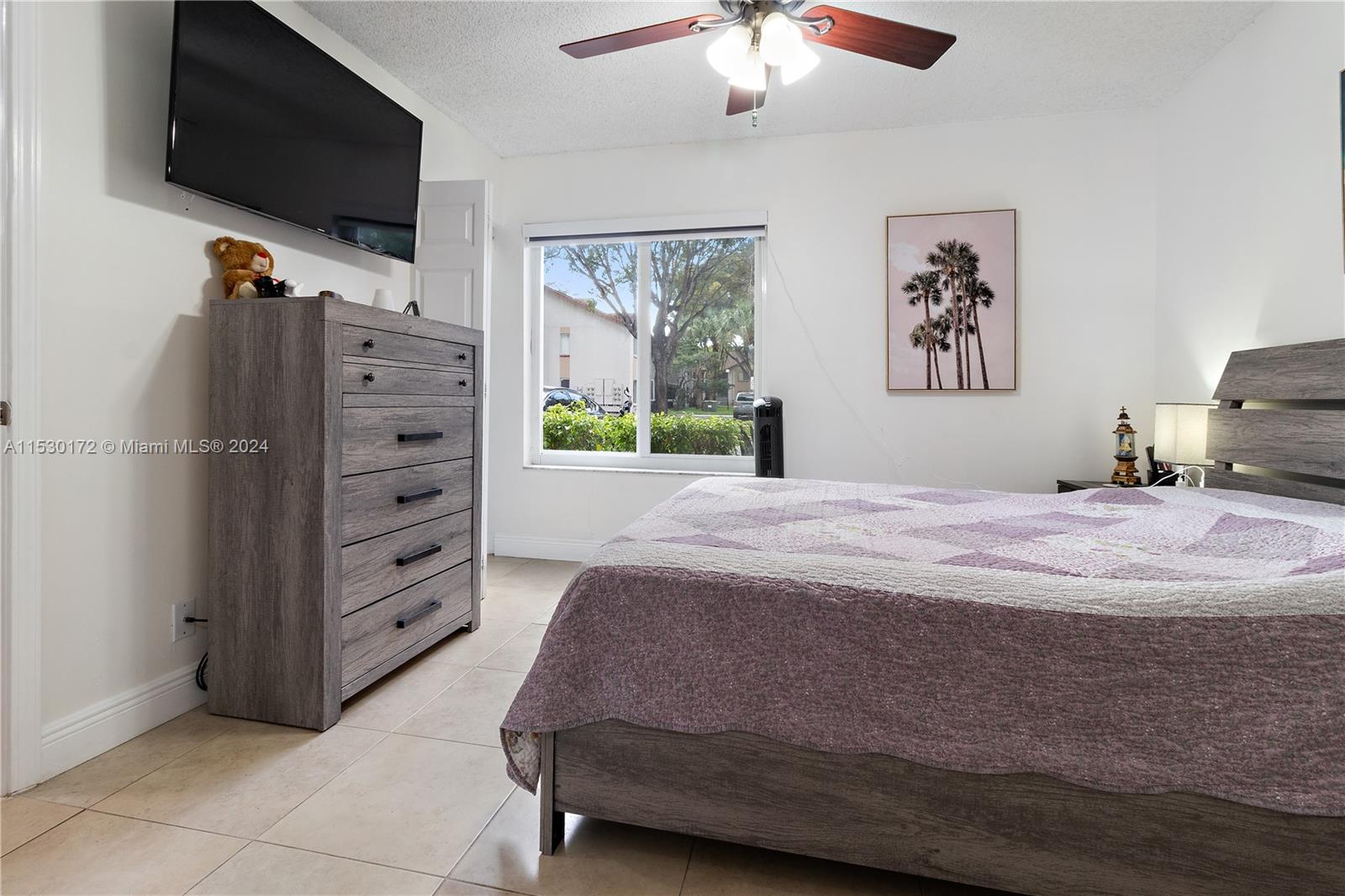 9201 Southwest 138th Place, Unit 9201 Miami, FL 33186 - Photo 10 of 20 a bedroom with a bed dresser and a flat screen tv