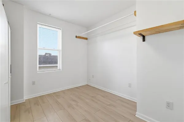 a view of a small space with wooden floor and a window