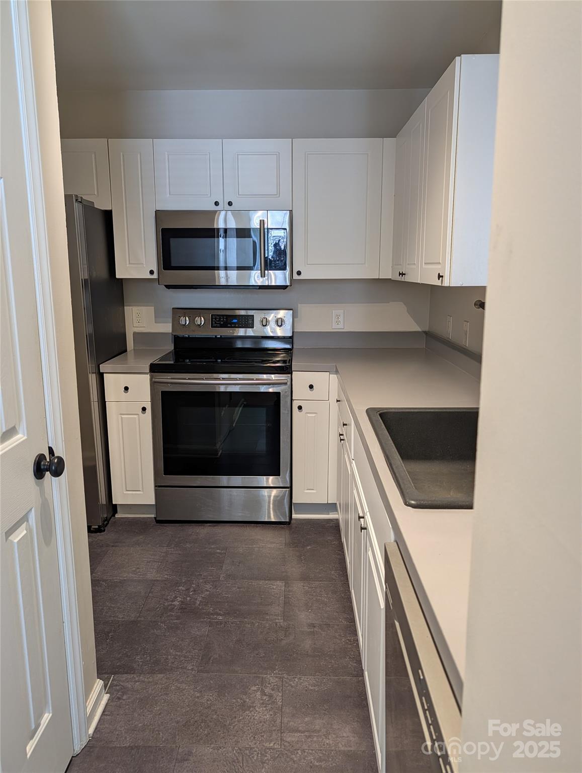5622 Osprey Cove Drive Raleigh, NC 27604 - Photo 11 of 30 a kitchen with stainless steel appliances a stove a microwave and a sink