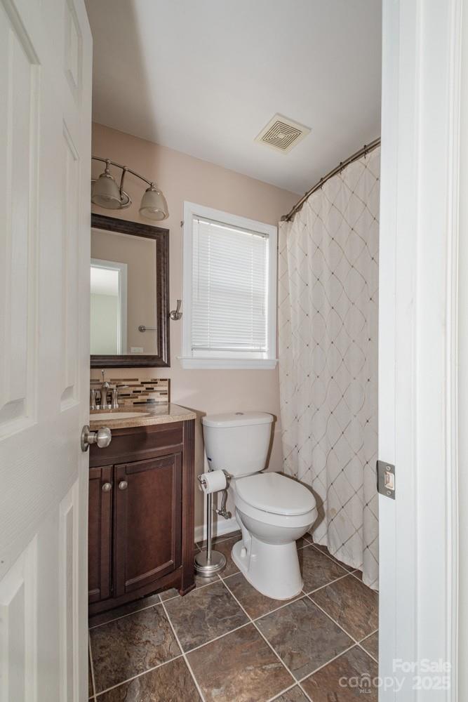 5622 Osprey Cove Drive Raleigh, NC 27604 - Photo 20 of 30 a bathroom with a toilet a sink and a window