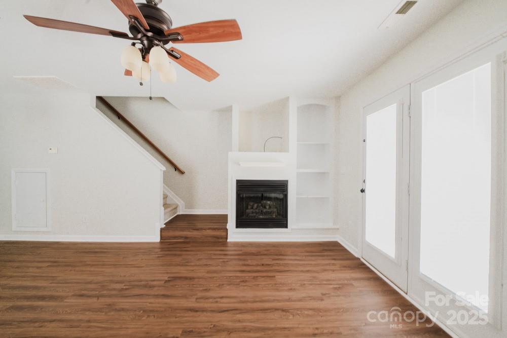 5622 Osprey Cove Drive Raleigh, NC 27604 - Photo 8 of 30 a view of a livingroom with wooden floor a ceiling fan and staircase