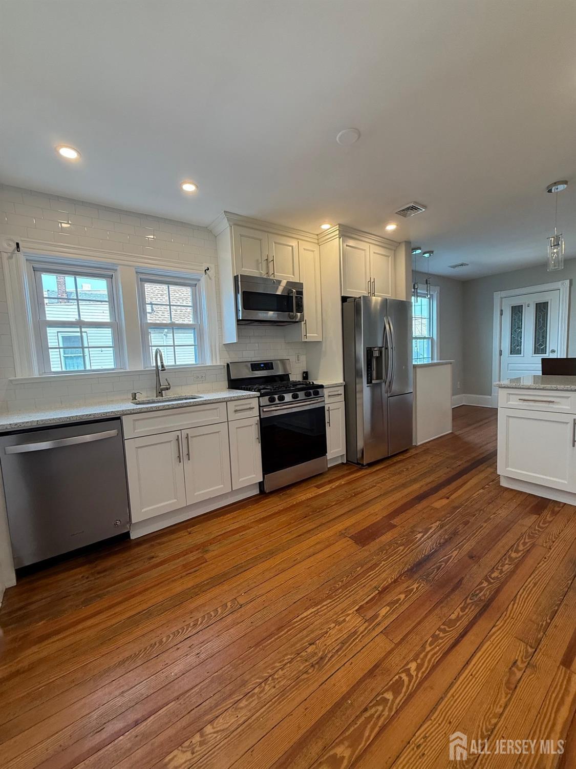 187 Broad Street, Unit 2 Perth Amboy, NJ 08861 - Photo 1 of 1 a large kitchen with stainless steel appliances granite countertop a stove a sink dishwasher and a refrigerator with wooden floor