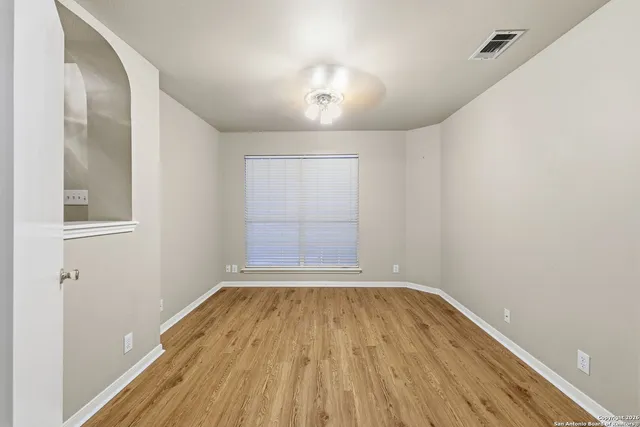 a view of empty room with wooden floor
