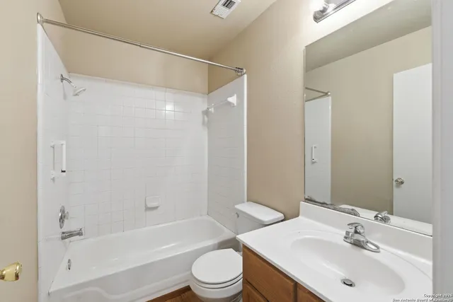 a bathroom with a bathtub shower sink vanity mirror and toilet