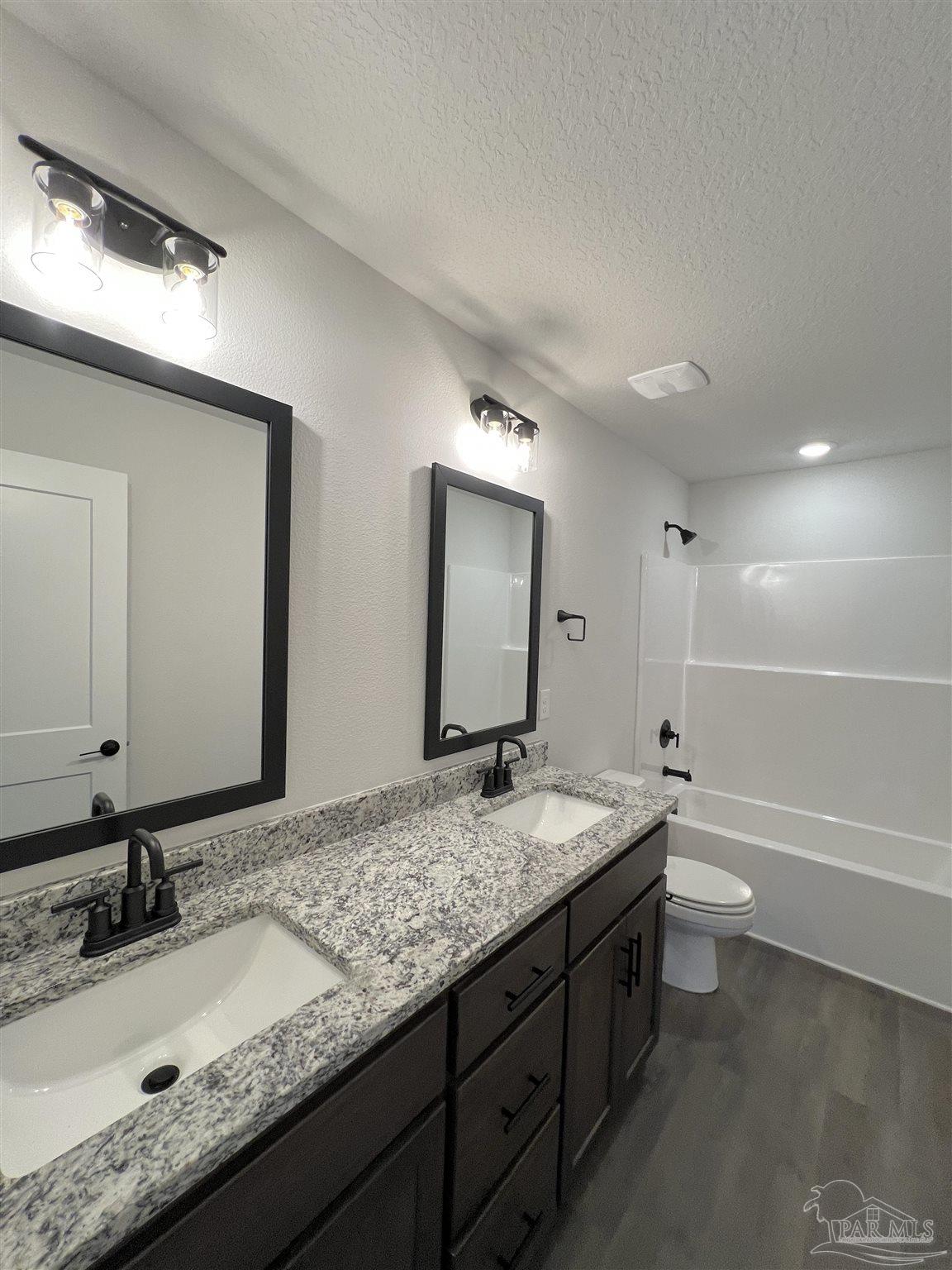 940 Rustling Pnes Road, Unit 13B Cantonment, FL 32533 - Photo 11 of 14 a bathroom with a granite countertop double vanity sink and a mirror