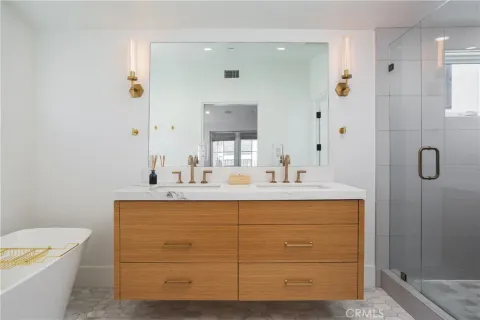 a bathroom with a sink a toilet a mirror and shower