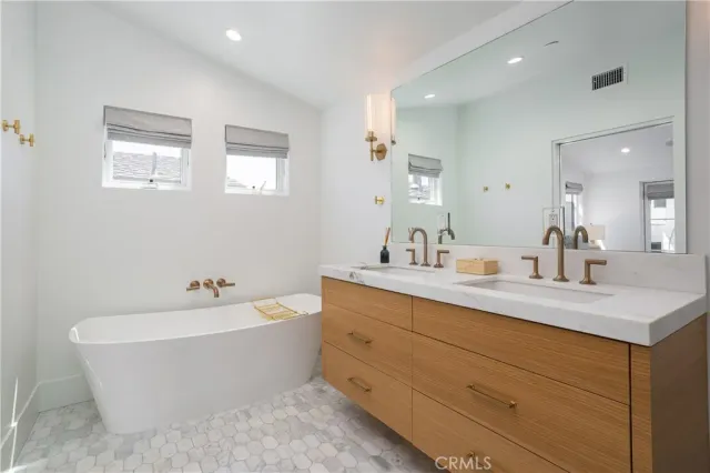 a bathroom with a bathtub sink and mirror