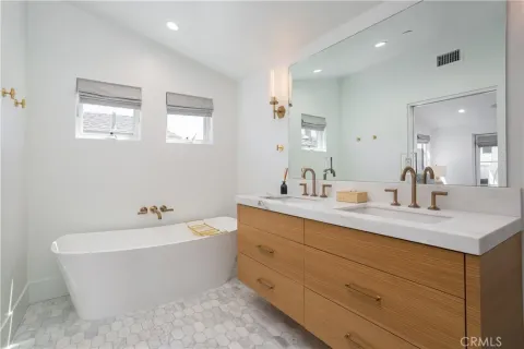a bathroom with a bathtub sink and mirror