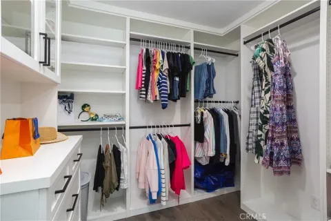 a view of walk in closet with clothes and shoes