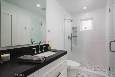 a bathroom with a granite countertop sink toilet and shower