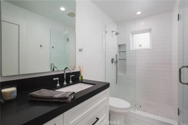 a bathroom with a sink a toilet and shower