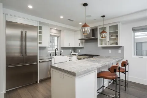 a kitchen with stainless steel appliances granite countertop a sink a stove a refrigerator and island