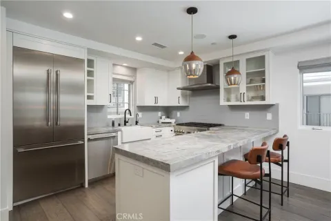 a kitchen with stainless steel appliances granite countertop a sink a stove a refrigerator and island