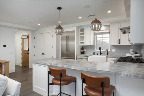 a kitchen with stainless steel appliances granite countertop a kitchen island a stove a table and chairs in it