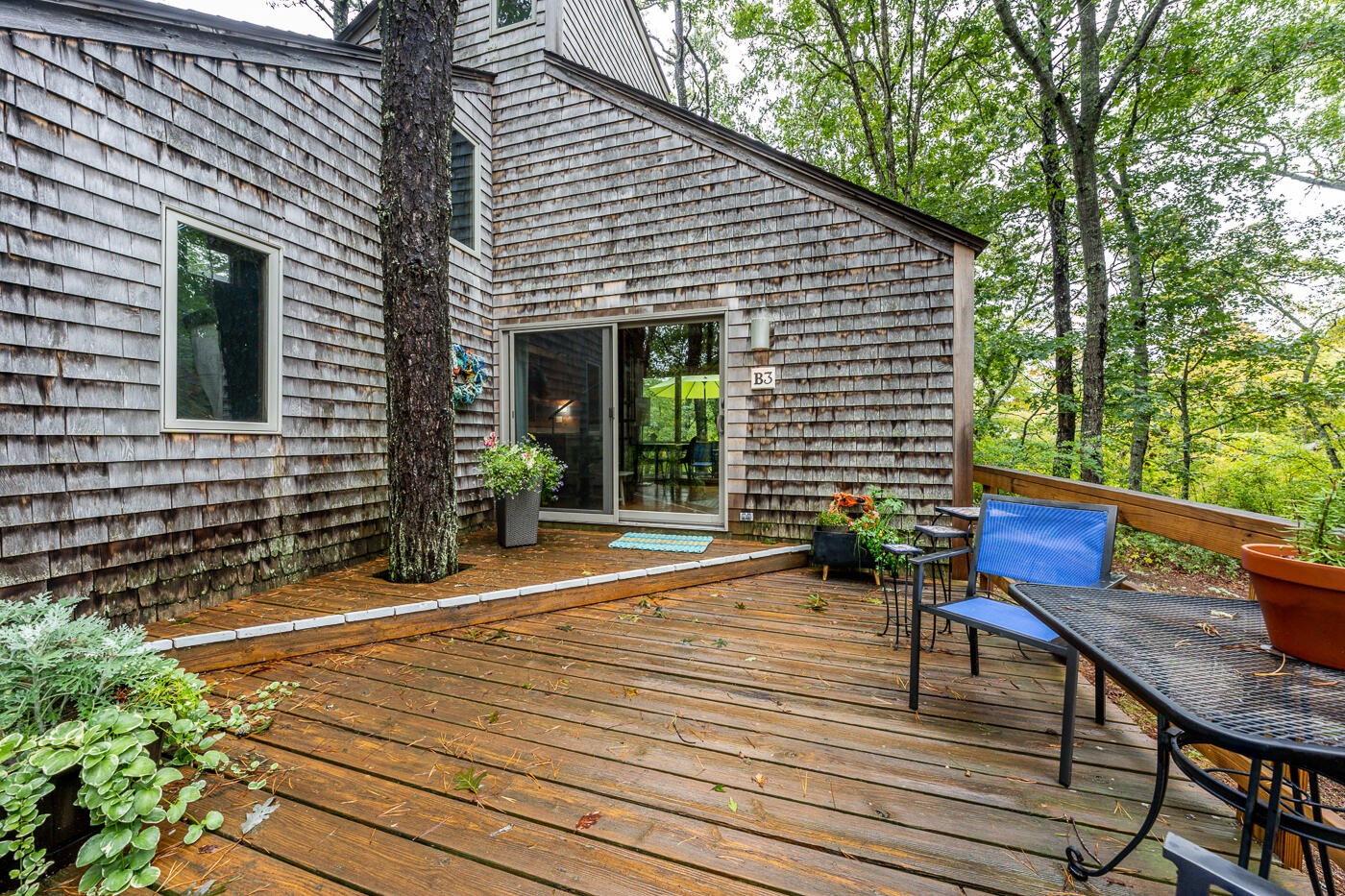 1780 Route 6, Unit B3 Wellfleet, MA 02667 - Photo 2 of 22 a view of a patio with table and chairs with wooden floor and fence