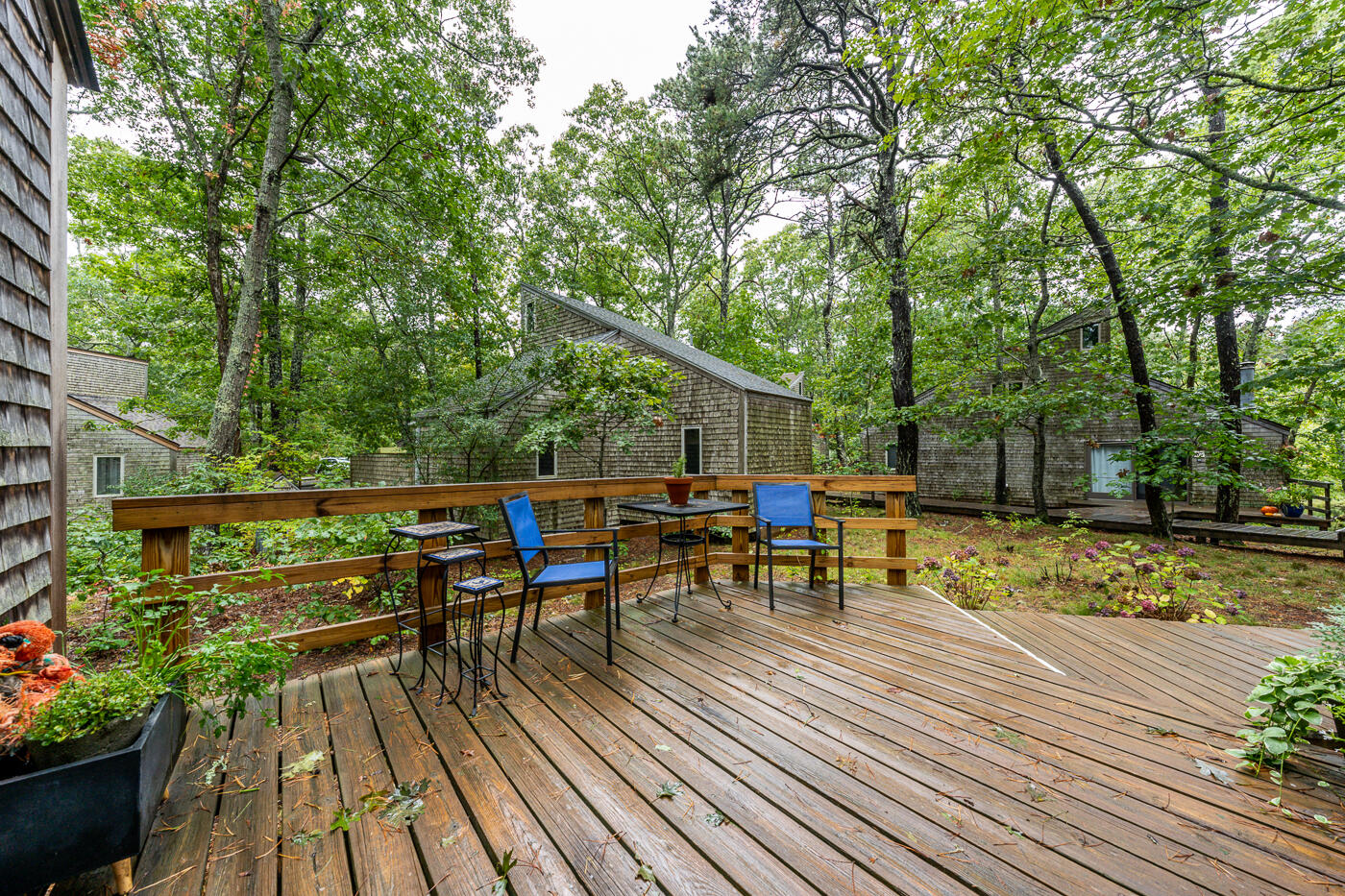 1780 Route 6, Unit B3 Wellfleet, MA 02667 - Photo 3 of 22 a view of a deck with chairs and plants with wooden floor and fence