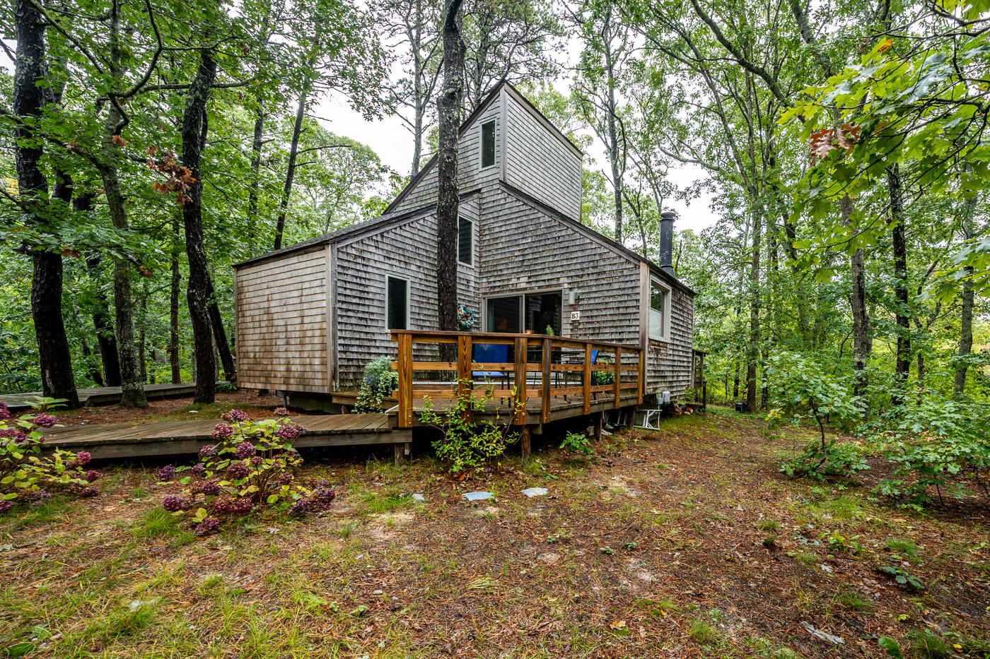 1780 Route 6, Unit B3 Wellfleet, MA 02667 - Photo 4 of 22 a backyard of a house with wooden fence and large trees