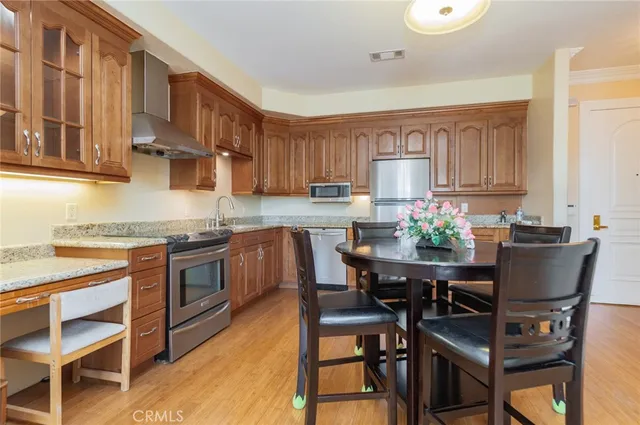 a kitchen with granite countertop wooden cabinets and stainless steel appliances
