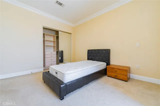 a spacious bedroom with a bed and a cabinet