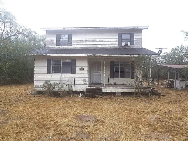 a view of a house with a yard and sitting area