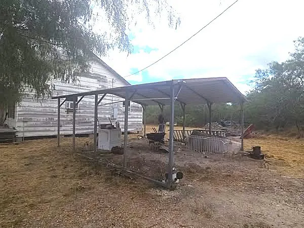 a backyard of a house with barbeque oven table and chairs