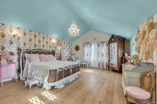 a spacious bedroom with a large bed and a chandelier
