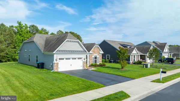 a view of a big house with a big yard and large trees