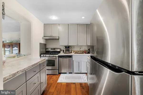 a kitchen with a sink stainless steel appliances and white cabinets