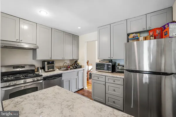 a kitchen with stainless steel appliances granite countertop a refrigerator sink and stove
