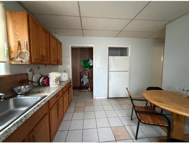 a kitchen with a sink a stove cabinets and a dining table