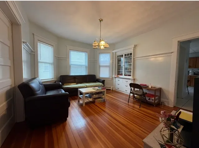 a living room with furniture a window and wooden floor