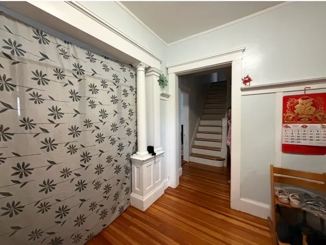 a view of a hallway with wooden floor and staircase