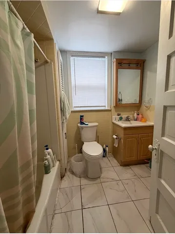 a bathroom with a toilet sink and mirror