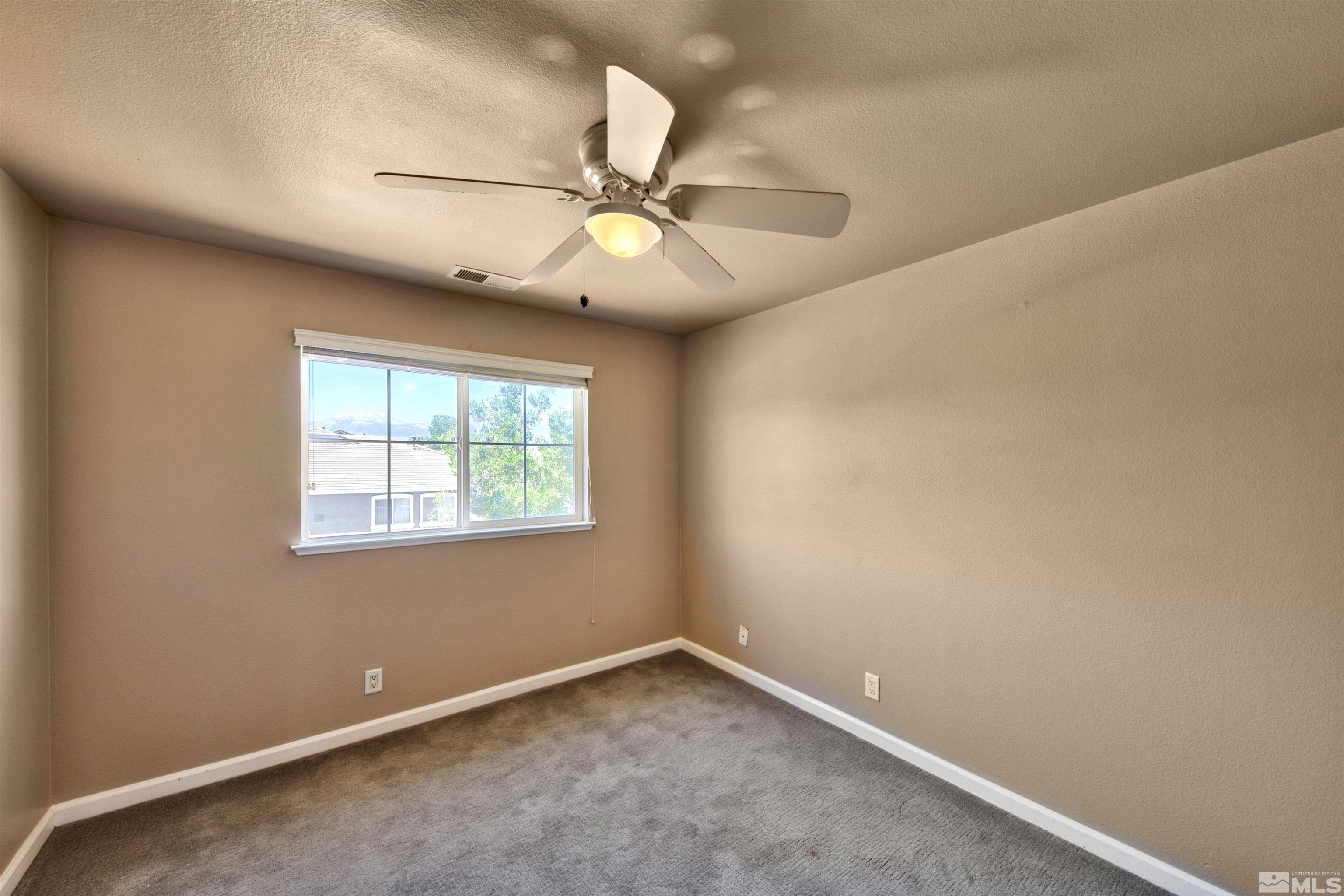 10084 Silver Star Drive Reno, NV 89521 - Photo 14 of 26 an empty room with a window and a fan