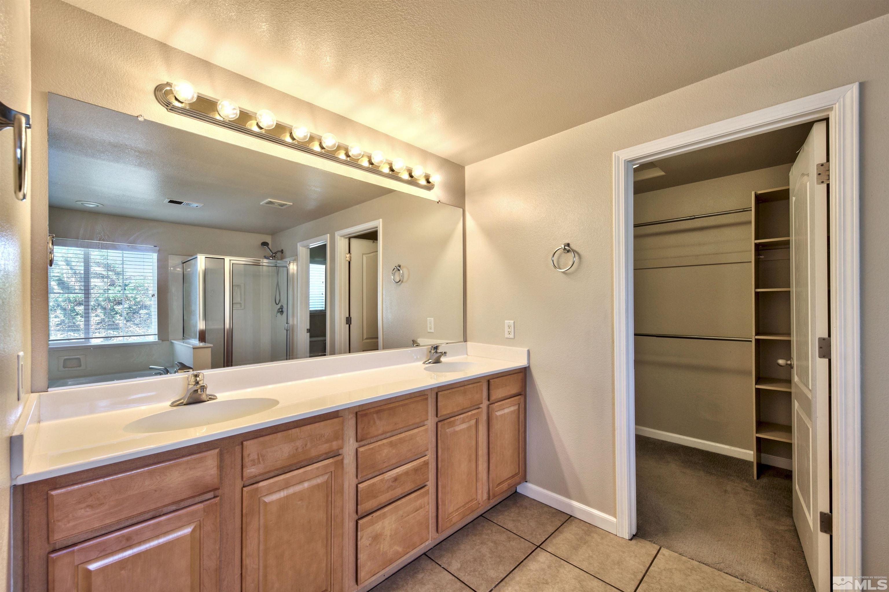 10084 Silver Star Drive Reno, NV 89521 - Photo 20 of 26 a bathroom with a double vanity sink and a mirror