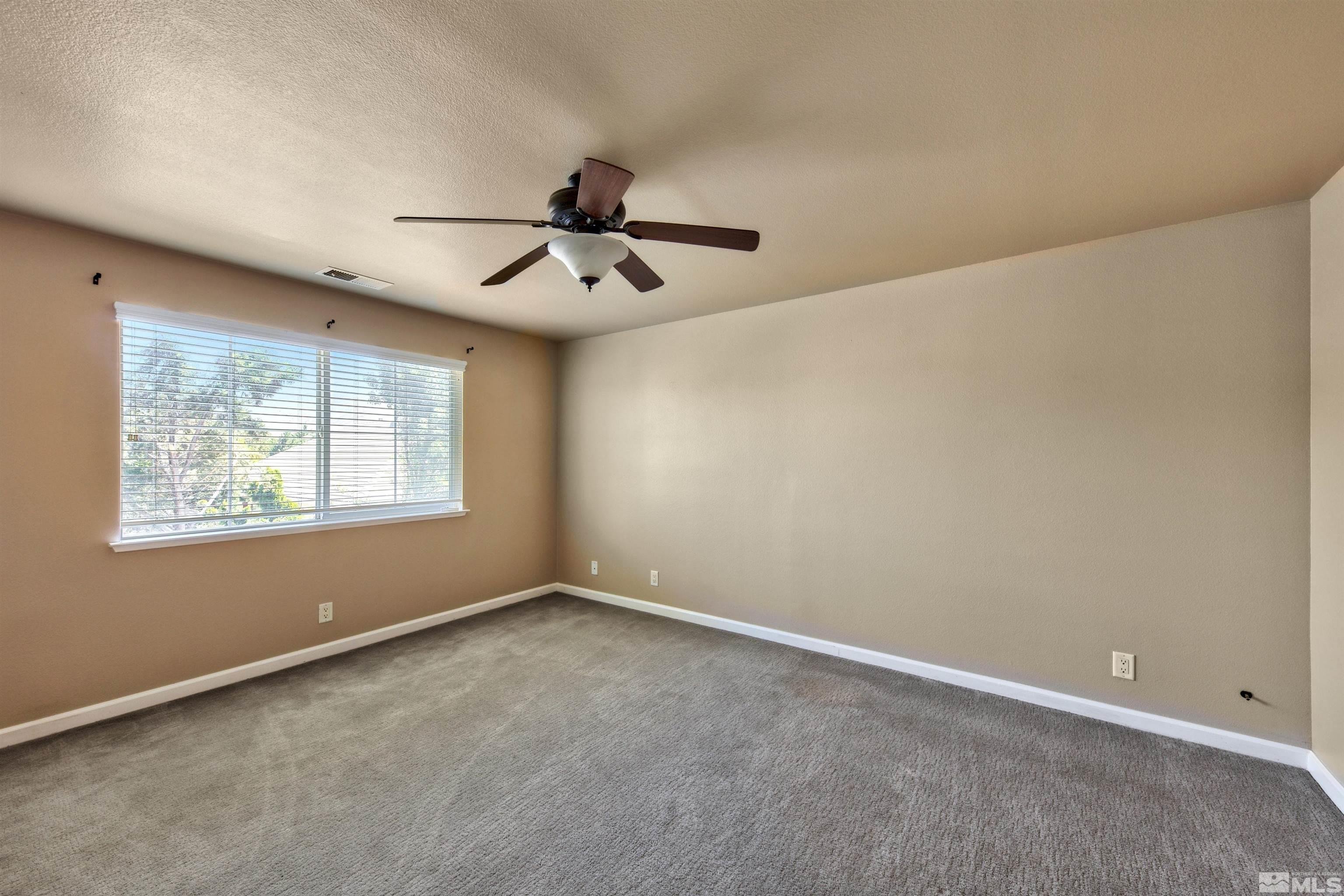 10084 Silver Star Drive Reno, NV 89521 - Photo 23 of 26 an empty room with windows and ceiling fan