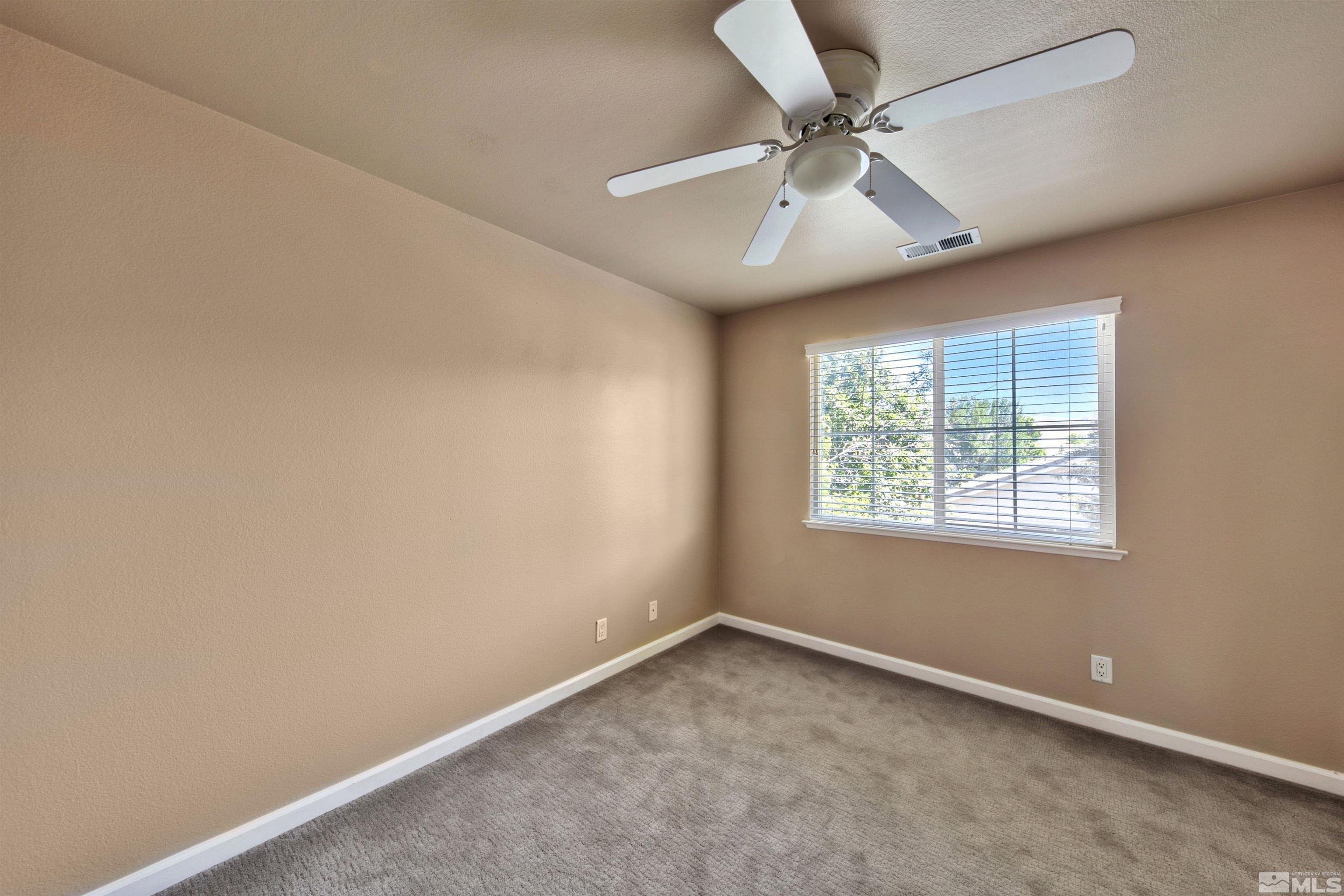 10084 Silver Star Drive Reno, NV 89521 - Photo 24 of 26 an empty room with a window and a fan