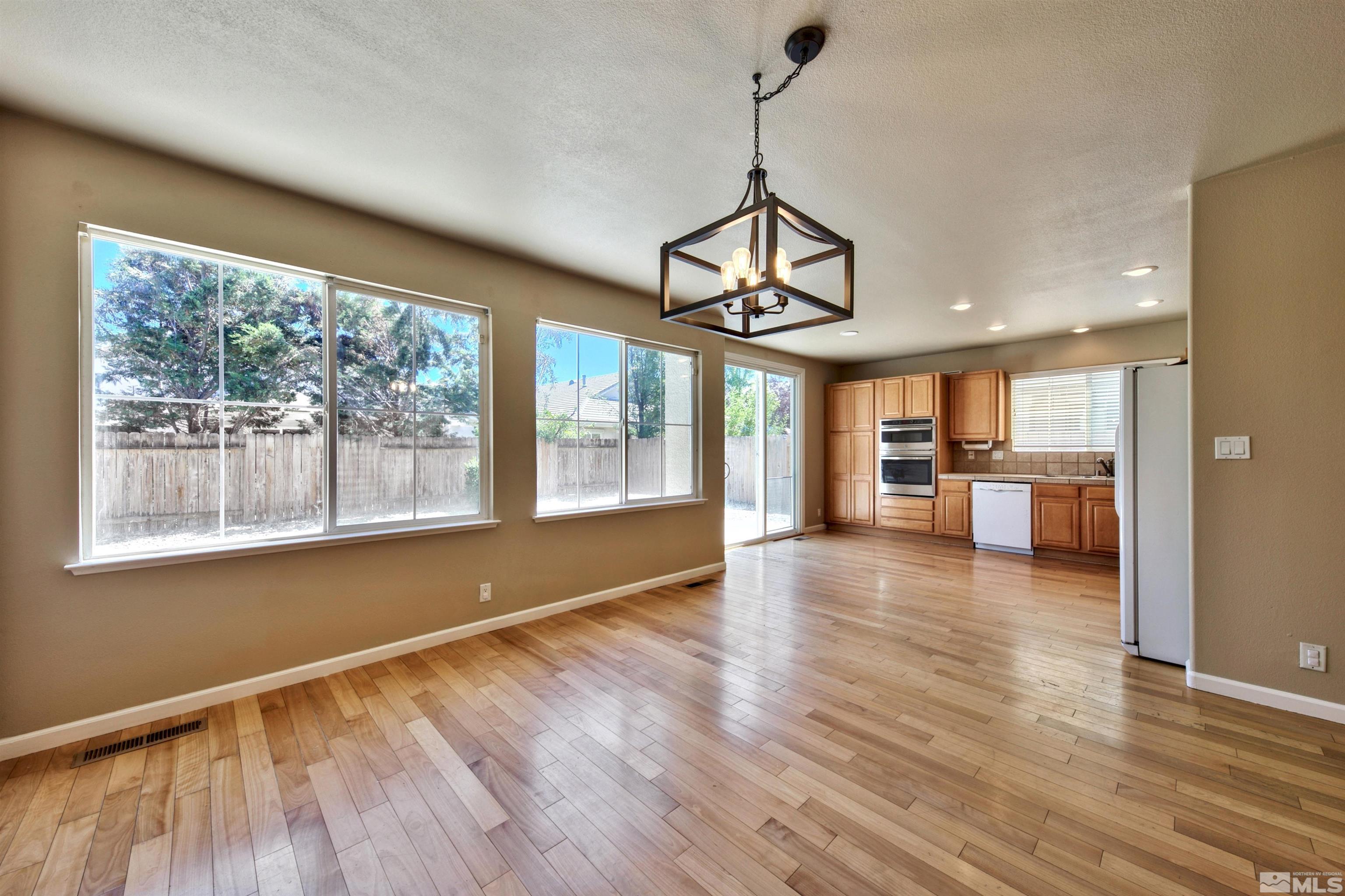 10084 Silver Star Drive Reno, NV 89521 - Photo 6 of 26 a view of a room with wooden floor and windows