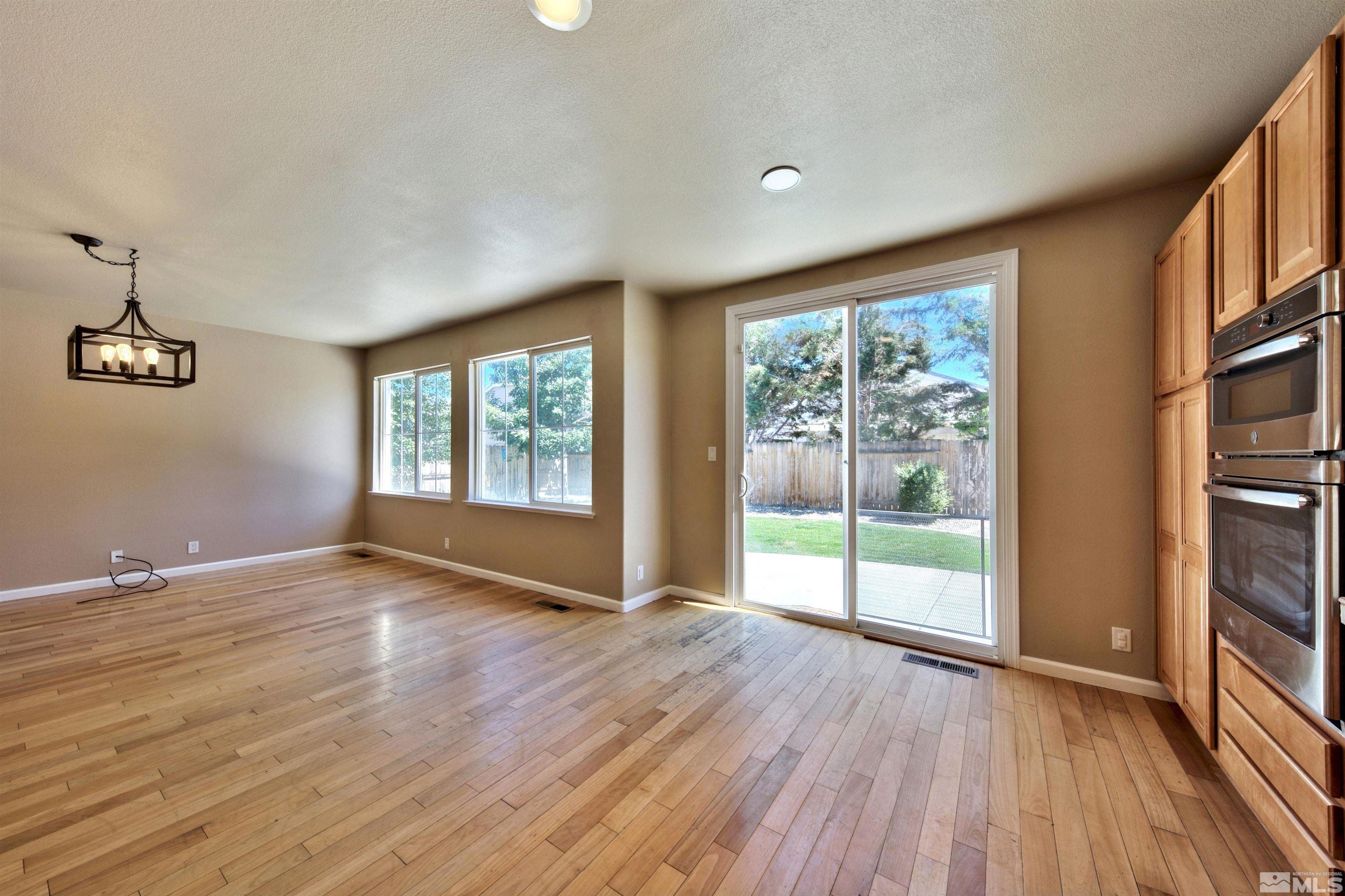 10084 Silver Star Drive Reno, NV 89521 - Photo 9 of 26 a view of an empty room with wooden floor and a window