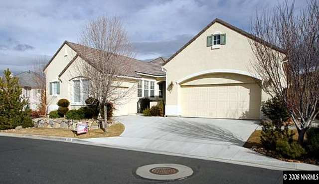 1550 Caughlin Creek Road Reno, NV 89519 - Photo 2 of 9 a view of a white house with large windows and a table and chairs in yard