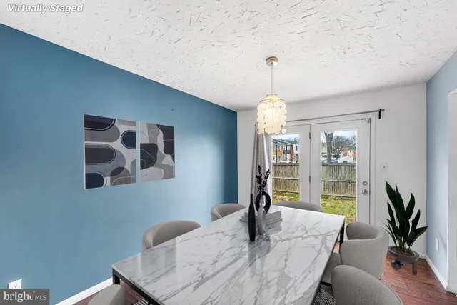 a dining room with furniture potted plants and wooden floor