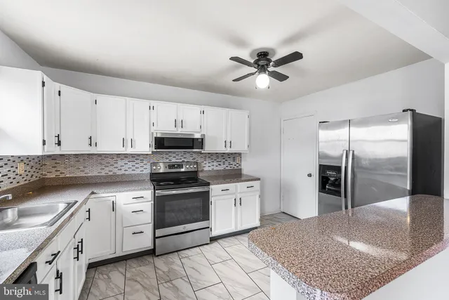 a kitchen with stainless steel appliances granite countertop a stove a sink and a refrigerator