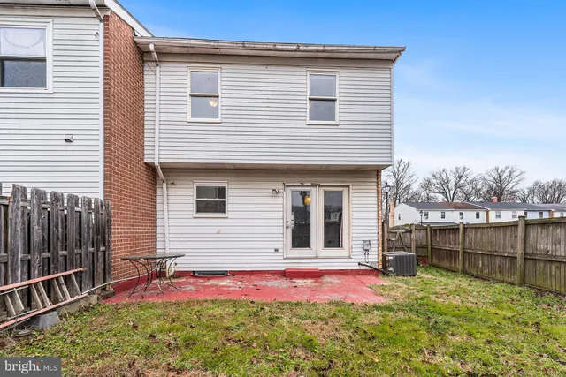a view of backyard of house with wooden deck and furniture