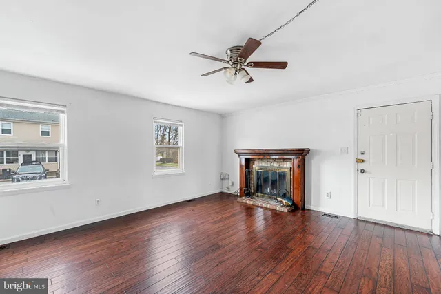 a view of empty room with wooden floor and fireplace
